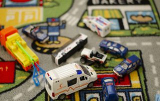 Accidente de tráfico representado con coches de juguete. Hay una ambulancia, tres coches de policía, una grúa y dos vehículos implicados en el accidente.