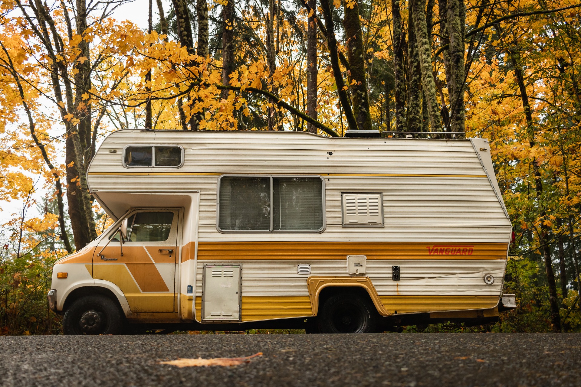 Típica autocaravana de los años noventa en un bosque en otoño. Seguro de Autocaravanas y Campers