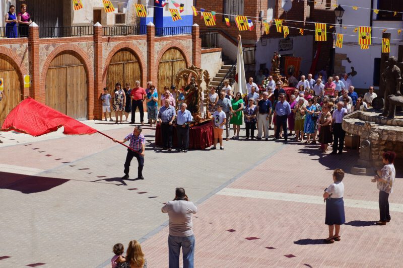 La plaza de Villafeliche en fiestas. Un hombre zarandea una bandera con el público expectante.