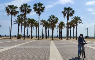 La modelo Tamara Pinuer posa con su bicicleta frente a las palmeras del paseo marítimo de la Malvarosa en Valencia. Seguro de Responsabilidad Civil para bicicletas.