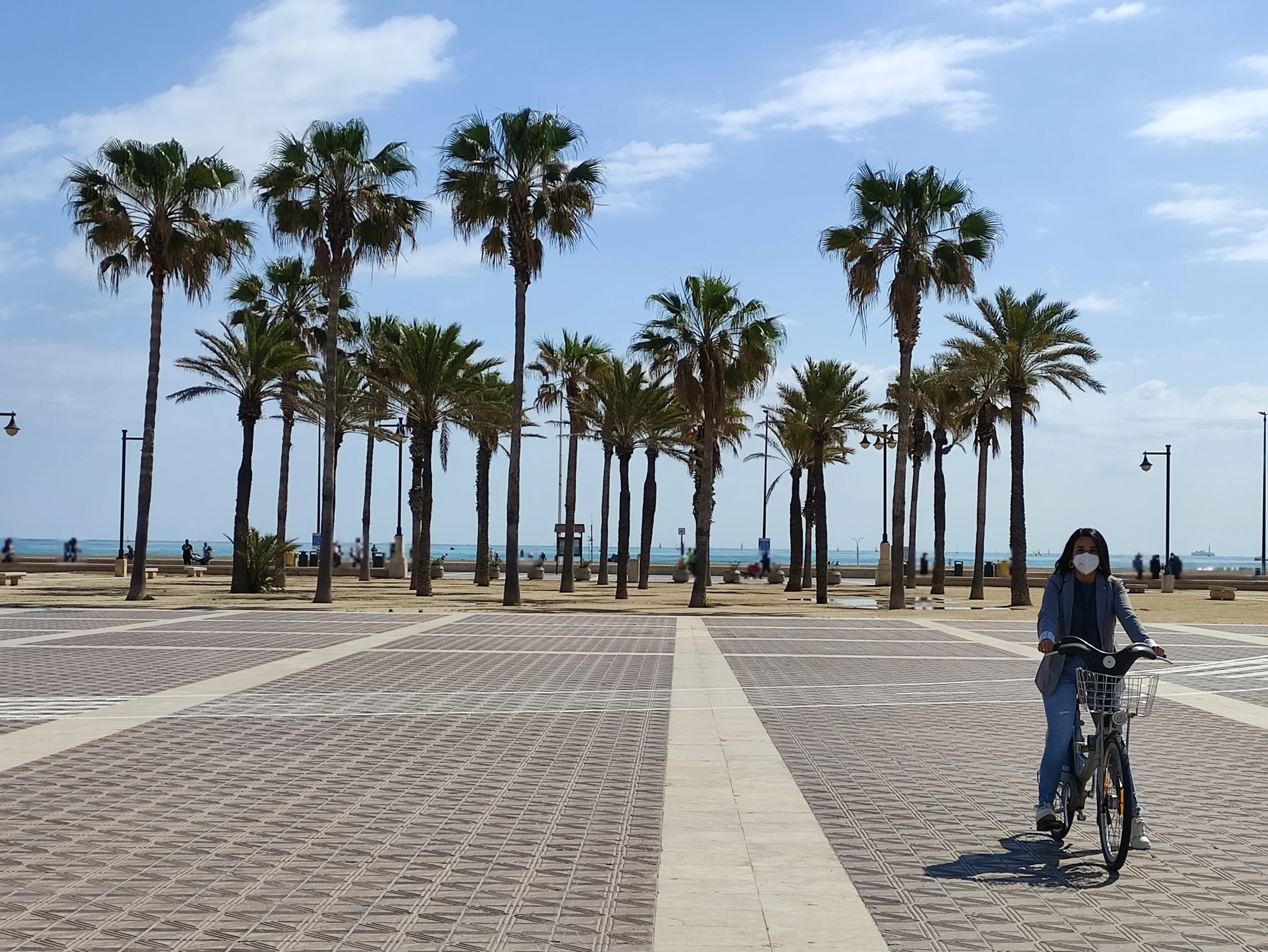 La modelo Tamara Pinuer posa con su bicicleta frente a las palmeras del paseo marítimo de la Malvarosa en Valencia. Seguro de Responsabilidad Civil para bicicletas.