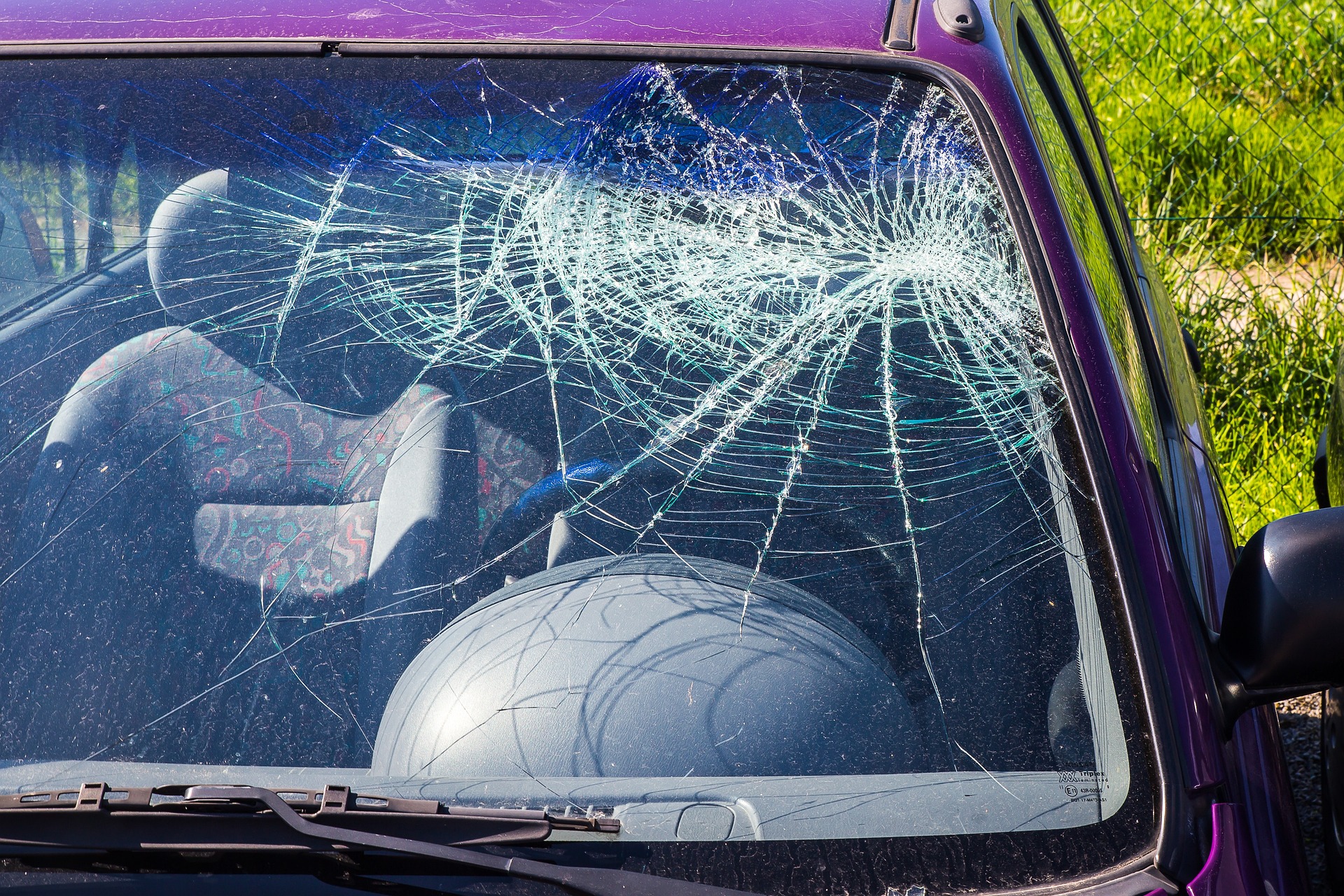 Luna de un coche rota por el impacto de un granizo en una tormenta de verano. Mejora tu seguro del automóvil incluyendo la póliza de protección contra fenómenos de la naturaleza.