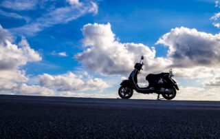 Vespa aparcada cerca del horizonte. Seguro de moto a tu medida.