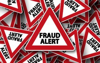 Señal de alarma en inglés con el texto 'Fraud Alert'. Aumenta el fraude en los seguros de automóvil en un 40 %.
