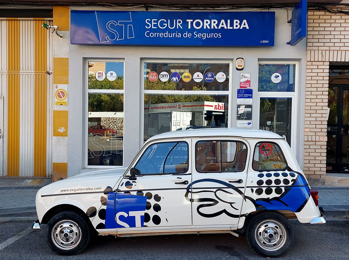 Fachada y coche promocional de Segur Torralba en la Avenida Reyes Católicos. Actualiza tus Seguros Personales en Segur Torralba.