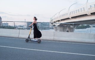 Mujer circulando en patinete eléctrico por una vía urbana en Valencia. Nueva ley de seguro obligatorio para patinetes eléctricos.