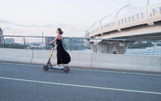 Mujer circulando en patinete eléctrico por una vía urbana en Valencia. Nueva ley de seguro obligatorio para patinetes eléctricos.