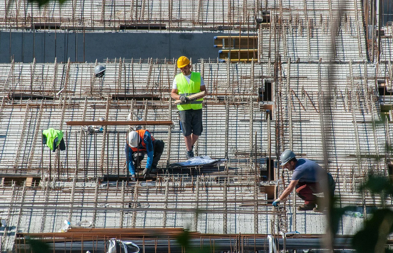 Trabajadores de la construcción realizando su actividad con equipos de protección, ejemplo de colectivo asegurable frente a accidentes laborales.